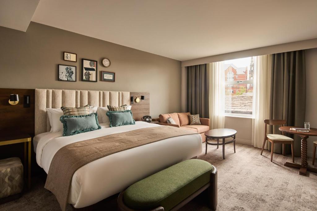 a hotel room with a large bed and a couch at Hotel Indigo Leeds by IHG in Leeds