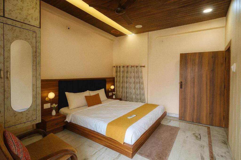 a bedroom with a large bed and a wooden door at Kashivas - 2BHK near Assi Ghat in Varanasi