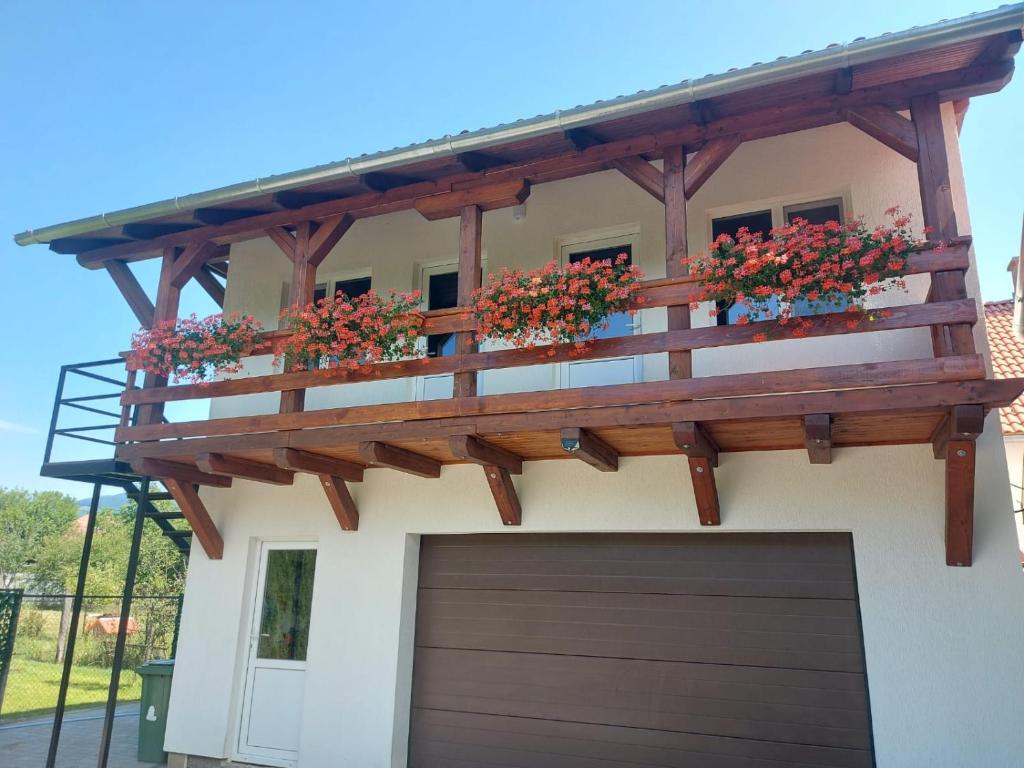 a pergola on a house with flower boxes on it at Giulia Guest House in Sovata