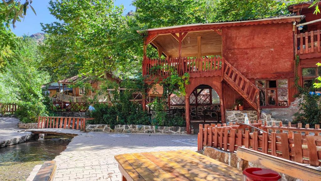 BüyükçakırにあるKapuzbaşı Baştürk Tesisiの川沿いのバルコニー付きの建物