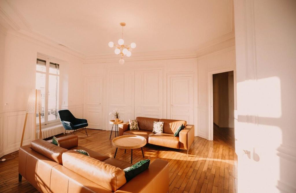 un salon avec un canapé et une table dans l'établissement Grand appartement Haussmannien 160m2, à Besançon