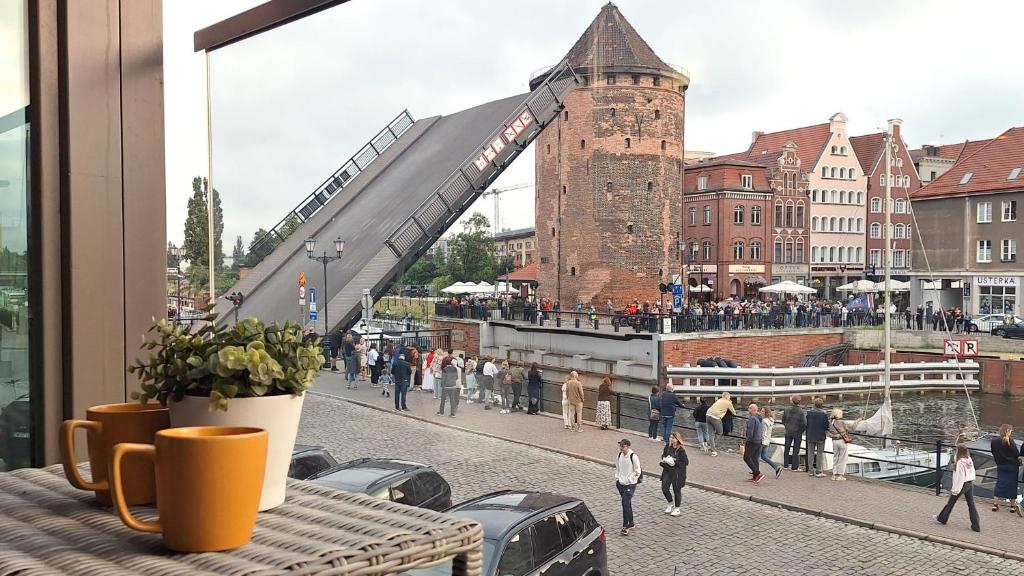 Blick auf eine Brücke mit Menschen, die auf der Straße gehen in der Unterkunft Waterlane Riverside - SPA, Pool, Gym &amp; Parking by Downtown Apartments in Danzig
