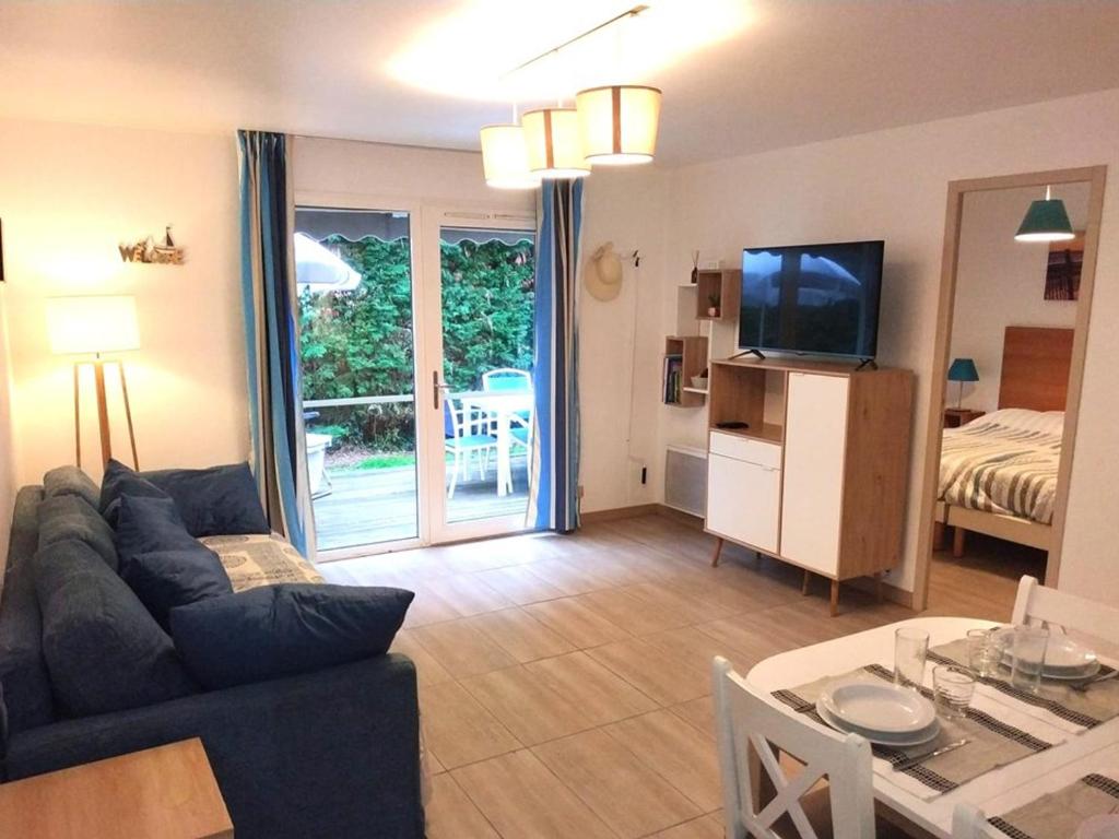 un salon avec un canapé, une télévision et une table dans l'établissement Appartement avec Piscine, Tennis et Terrasse à Soustons - FR-1-379-155, à Soustons