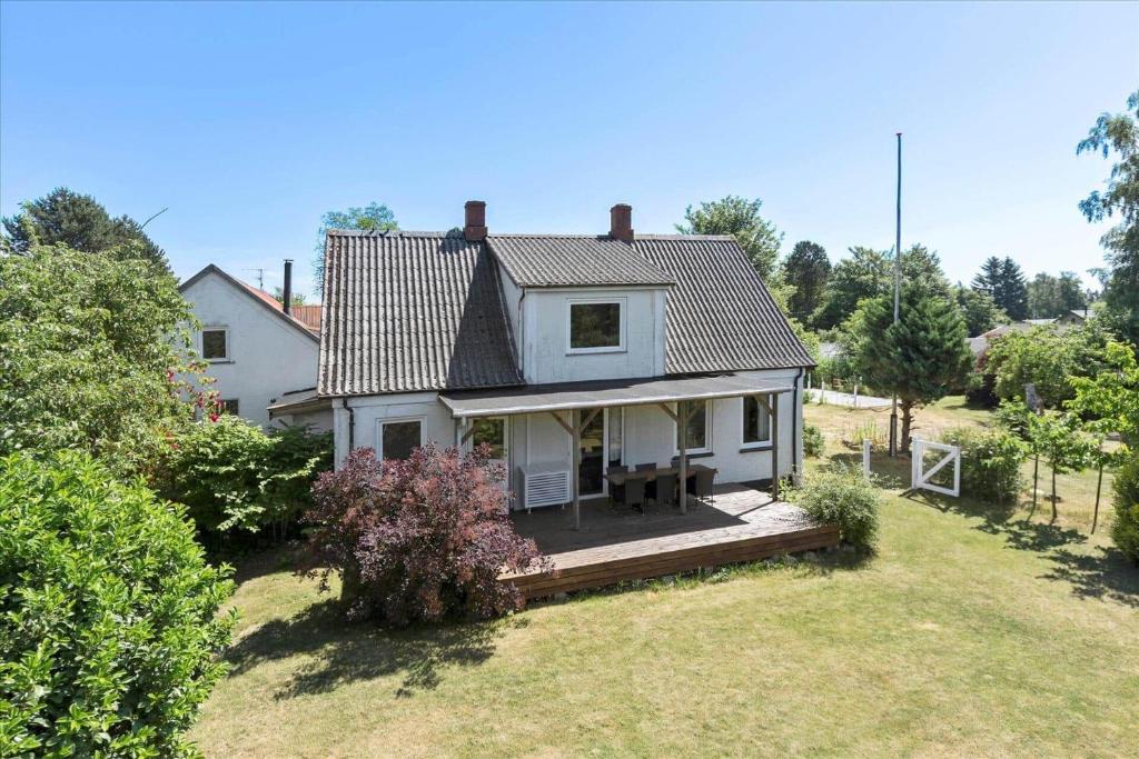 a white house with a deck in the yard at 3073-Stege-Bundgarnet-23 in Stege