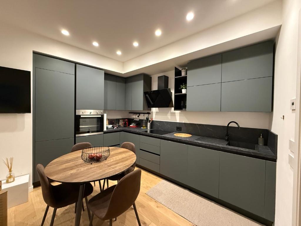 een keuken met een houten tafel en stoelen en een wastafel bij Diletta Luxury Apartment in Senigallia