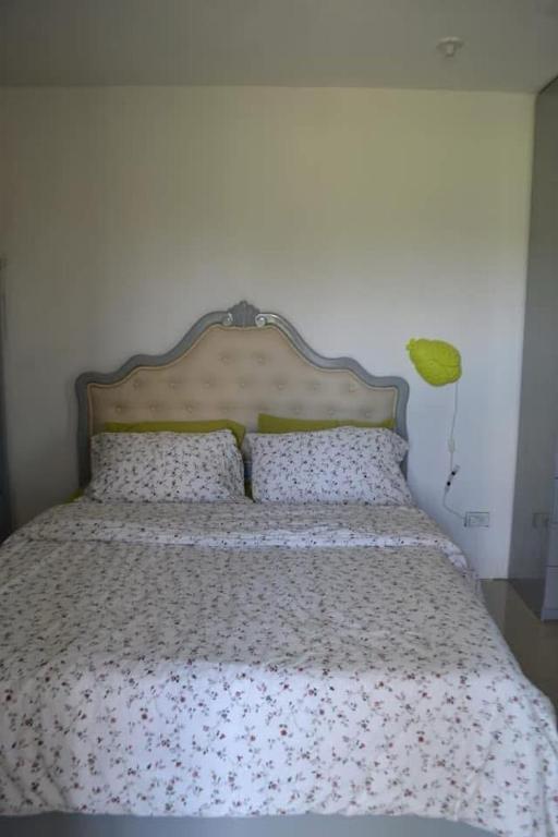 a bedroom with a bed with a floral bedspread at HTL Apartment in Aglalana