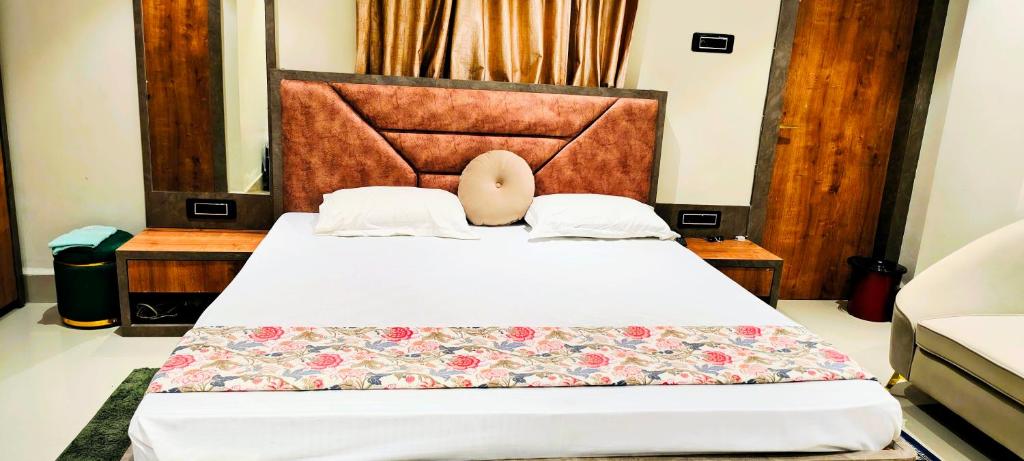 a bedroom with a large bed with a headboard at Manyavar Guest House Rooms & Family Service Flats in Deoghar