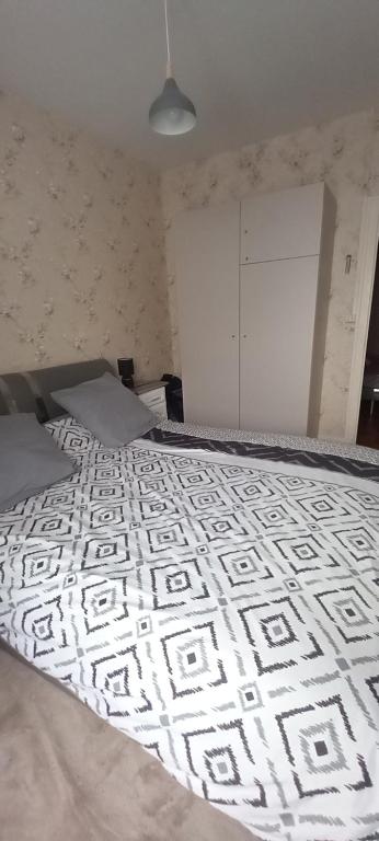 a bedroom with a bed with a black and white comforter at Maison cœur de ville in Marennes