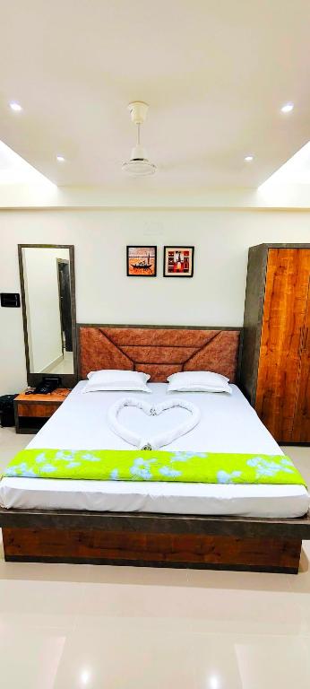 a bedroom with a large bed with a wooden headboard at Manyavar Guest House Rooms & Family Service Flats in Deoghar