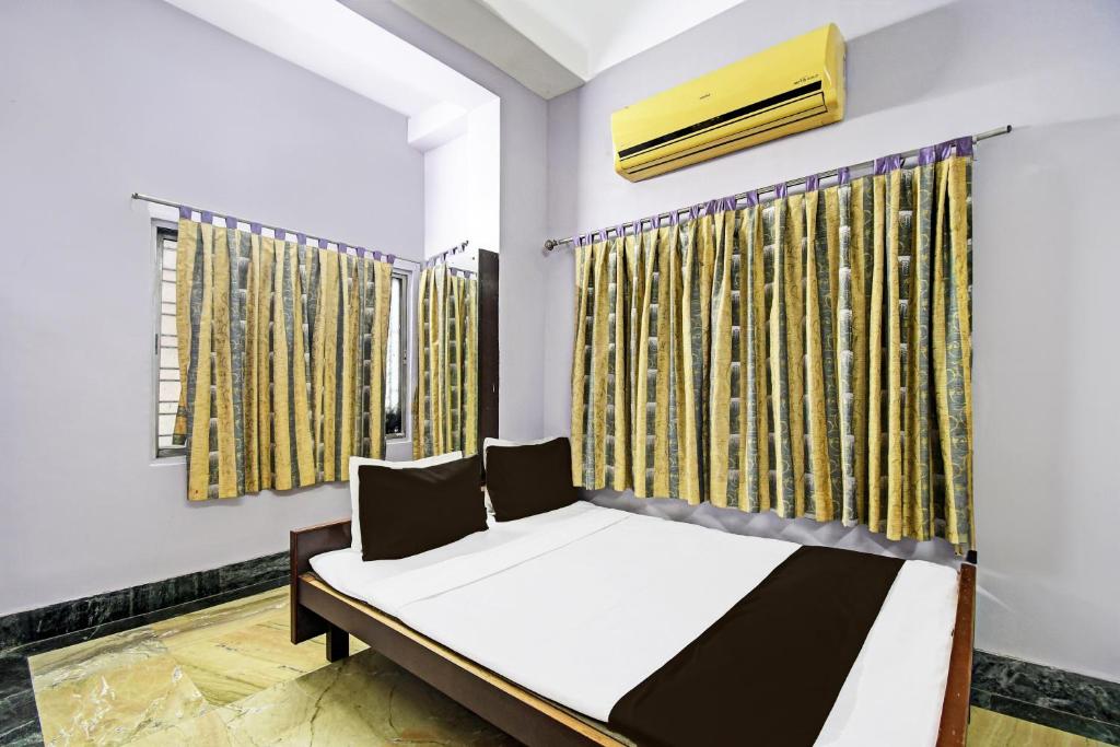 a bedroom with a bed and a window at Hotel O Arati House in Kolkata