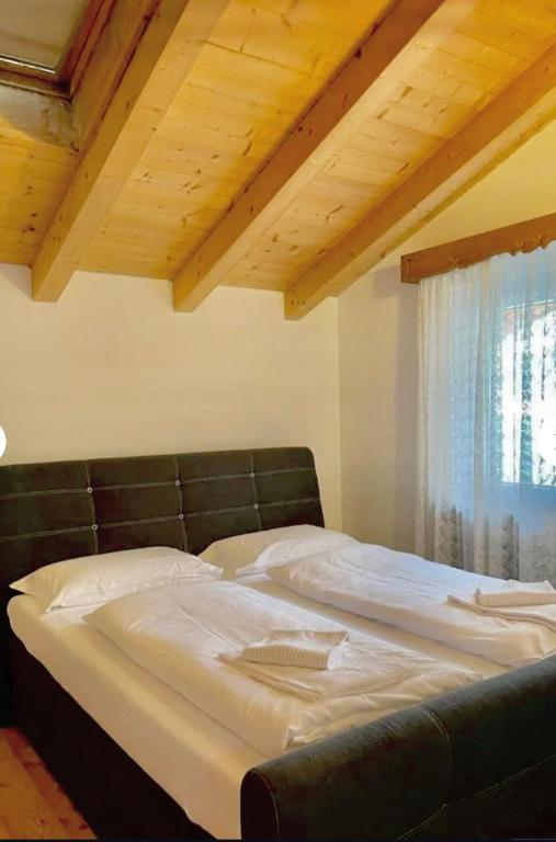 a large bed with a black leather headboard in a room at Cèsa Niki in Canazei