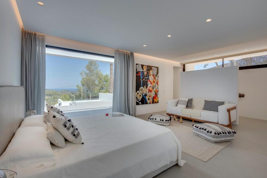 une chambre avec un grand lit et une grande fenêtre dans l'établissement Spectacular 5 Bedroom Villa Oasis in Ibiza, 1066, à San José