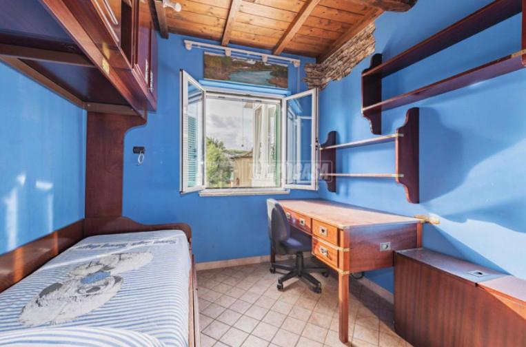 a bedroom with a desk and a bed and a window at Casa di Clara Fregene in Fregene