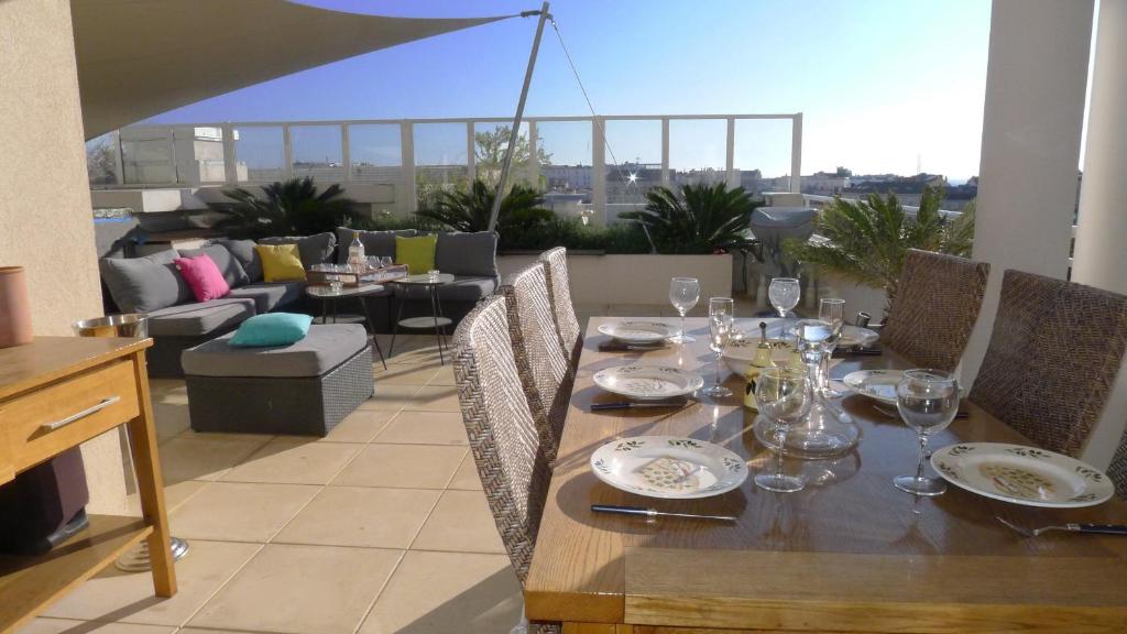 - une table en bois avec des verres à vin sur le balcon dans l'établissement BRISTOL PARK AP4467 by Riviera Holiday Homes, à Cannes