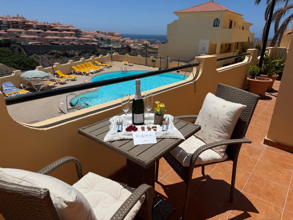 a table with a bottle of wine on a balcony at Sunny Apartment Loma de Arguineguín in Arguineguín