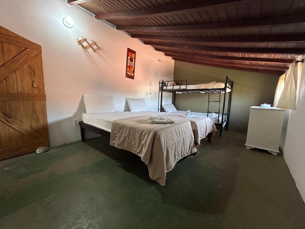 a bedroom with a bed and a wooden ceiling at Pousada Mojomar Buzios in Búzios