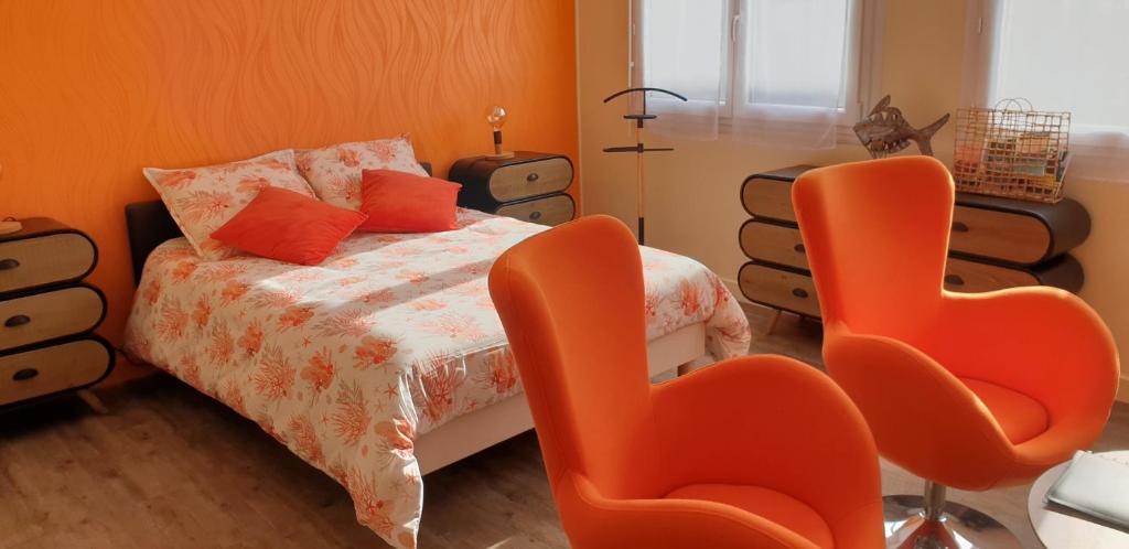 an orange bedroom with a bed and orange chairs at A 2 pas des iles à Concarneau in Concarneau