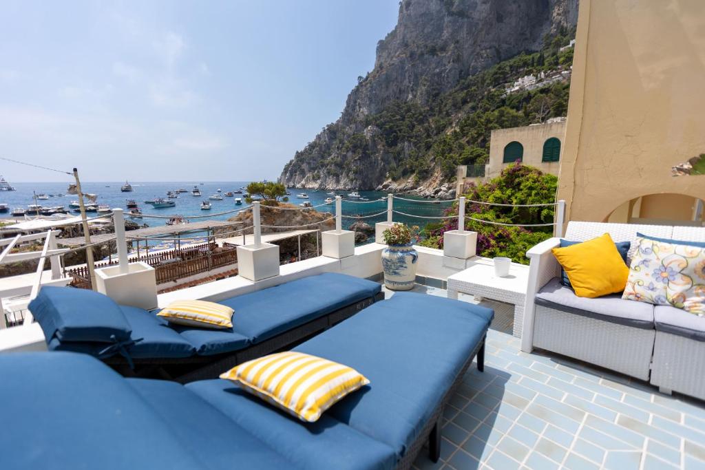 a balcony with blue couches and a view of the ocean at Villa Marea by My Villa Collection in Capri