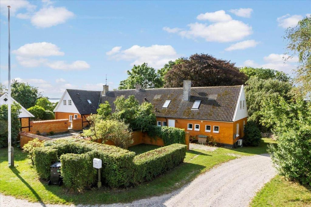 a house with hedges in front of a driveway at 7017-Bogo-By-Fruekildevej-17 in Bogø By