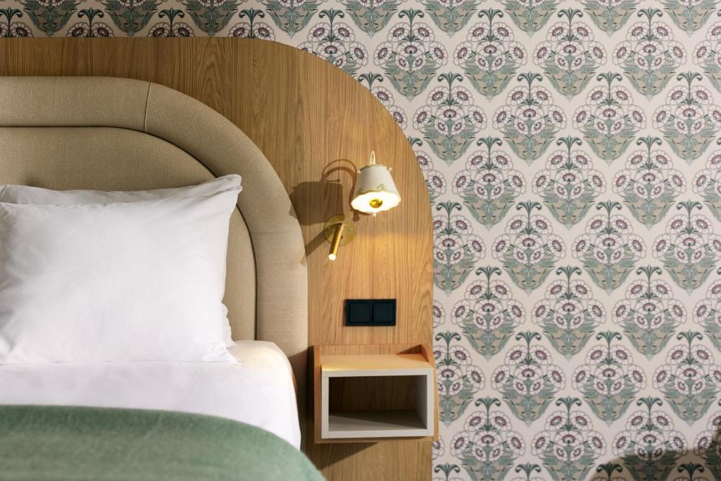 a bedroom with a bed and a table with a lamp at Van der Valk Hotel Volendam - Recently renovated in Volendam