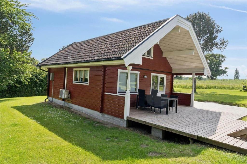 a small red house with a wooden deck at 8163-Praesto-Kohavevej-3 in Præstø
