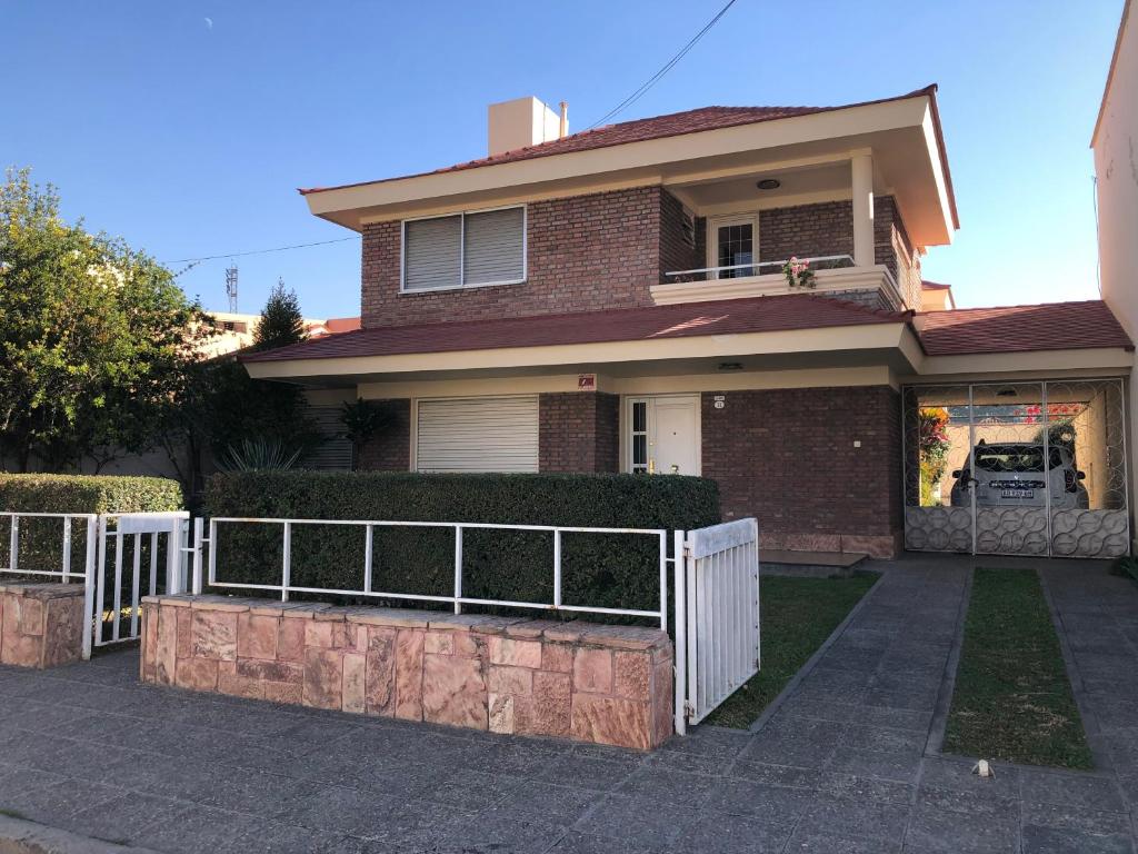a brick house with a white fence in front of it at Casa Hanami, habitación doble excelente ubicación in Salta