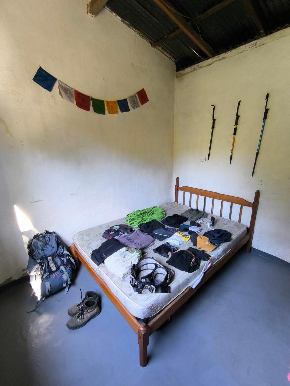 Una cama en una habitación con ropa. en Camping do Ser - Quarto Montanha, en Petrópolis