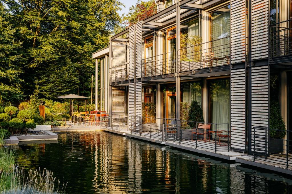 a house with a river in front of it at Relais & Châteaux Hotel Diepeschrather Mühle in Bergisch Gladbach
