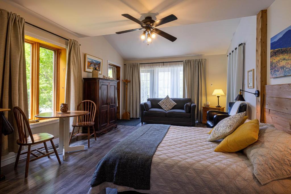 a bedroom with a bed and a desk and a chair at Chez Les Bergeron in Saint Aime Des Lacs