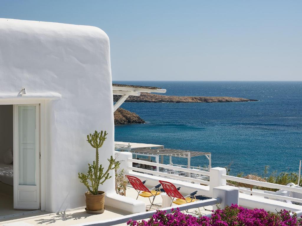 a balcony with chairs and a view of the ocean at Mykonos Lolita, a Resort to Live in Agios Sostis Mykonos