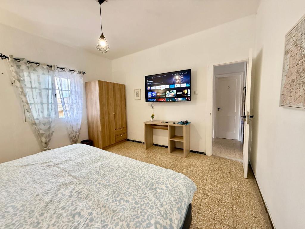 a bedroom with a bed and a desk and a television at Rooms La Laja 4 in Las Palmas de Gran Canaria