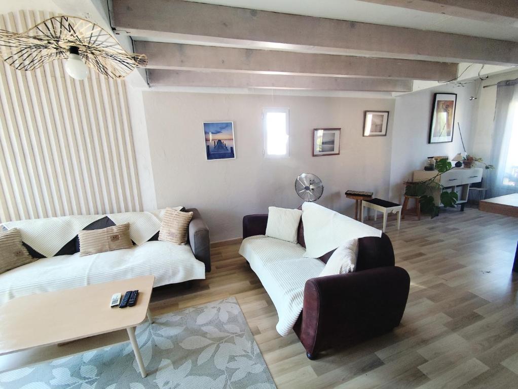 a living room with two couches and a table at Reve azur plage en duplex coeur de village in Le Pradet