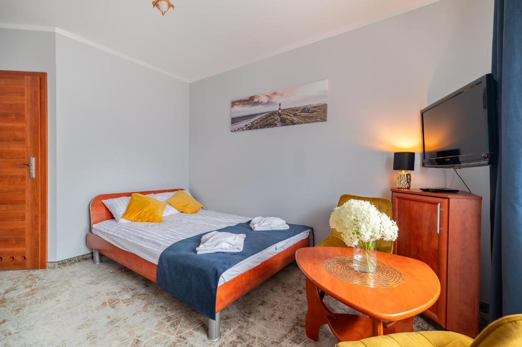 a small room with a bed and a table at Villa Morska, 350 m do plaży in Ustronie Morskie