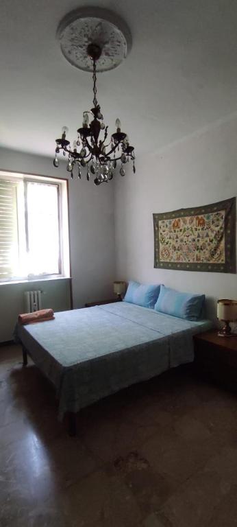 a bedroom with a large bed with a chandelier at La Tua Pausa Torinese in Turin