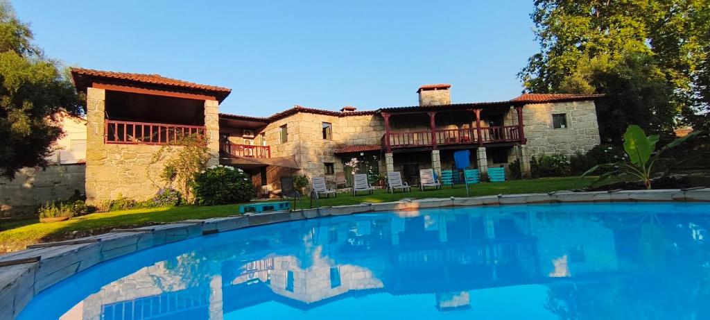 a house with a swimming pool in front of it at Casa Nova das Oliveiras in Braga