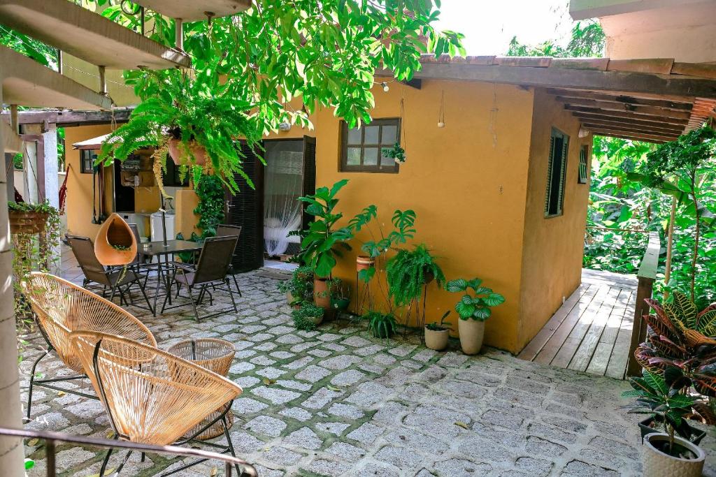イリャベラにあるChalés da Libélula | Refúgio entre praia e natureza em Ilhabelaの家のパティオ(椅子、テーブル付)