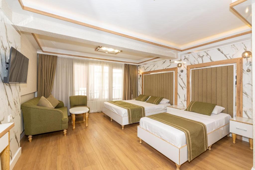 a hotel room with two beds and a couch at TAKSİM HAVANA HOTEL SUİTES in Istanbul