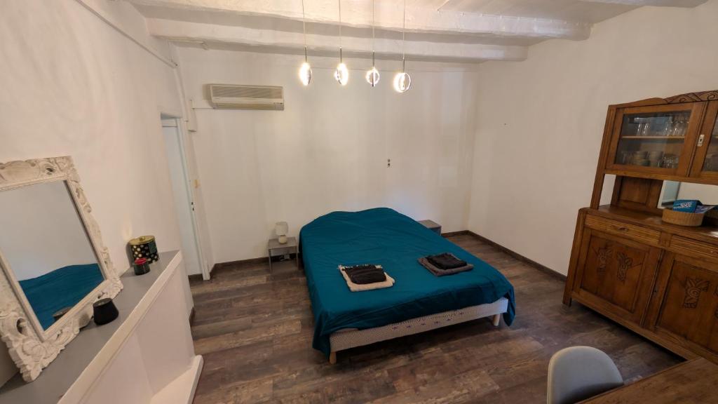 a bedroom with a blue bed and a mirror at Appartement de village in Monacia-dʼAullène