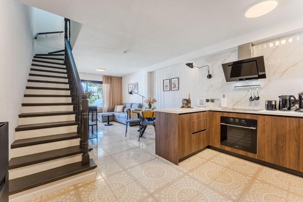 a kitchen and a living room with a staircase at Fairways Premium Duplex Suite in San Miguel de Abona