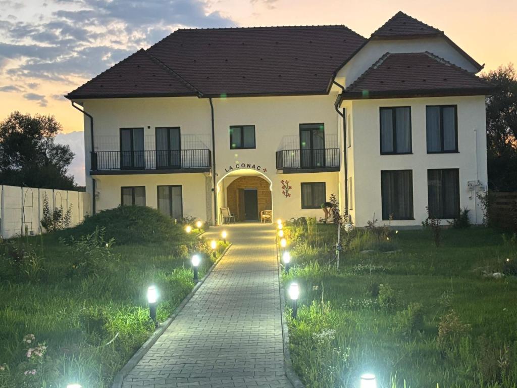 a large white house with lights in the yard at La Conac Sibiu in Sibiu