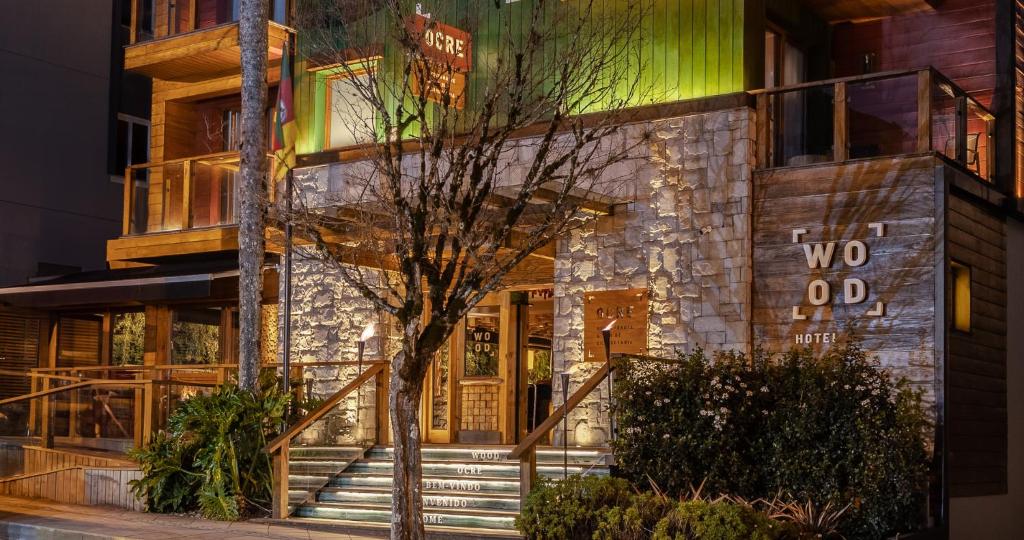 Un edificio con escaleras que conducen a la puerta principal. en Wood Hotel Gramado, en Gramado