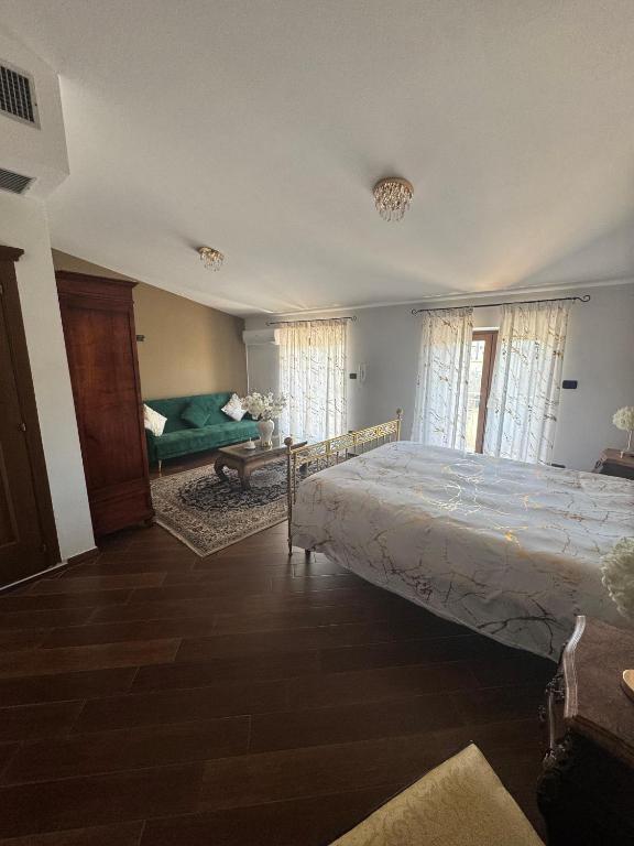 a bedroom with a bed and a couch and windows at B&B Anna in Marigliano