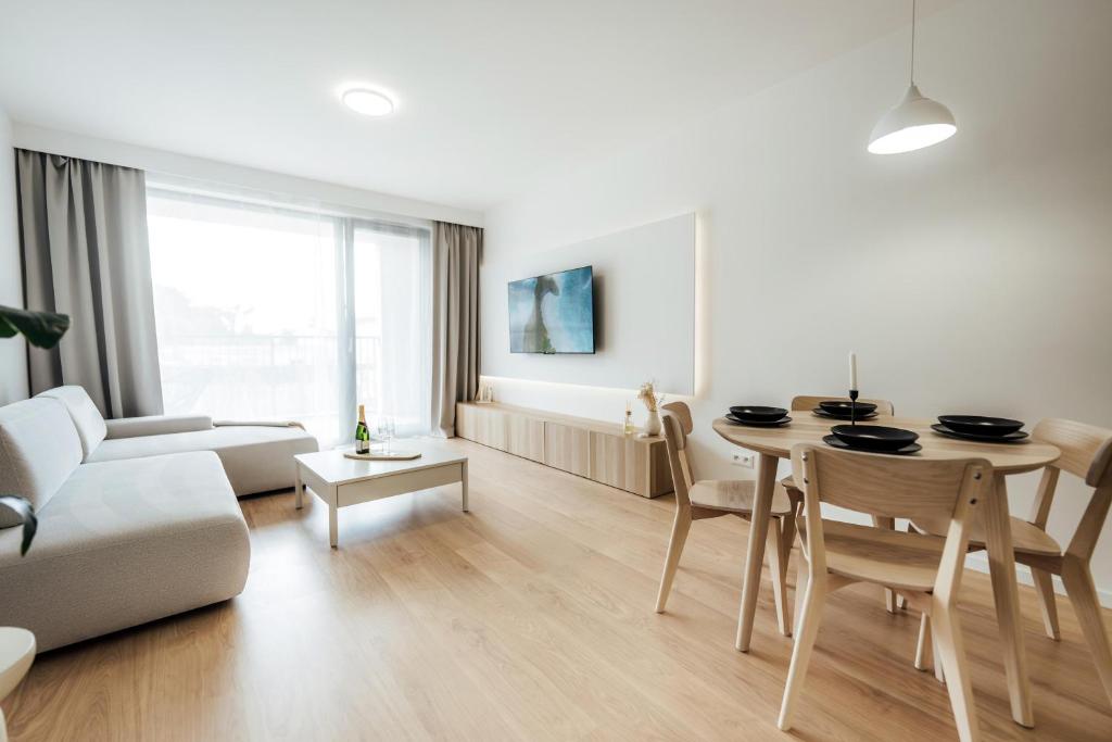 a white living room with a table and a couch at Severna Residence in Banská Bystrica