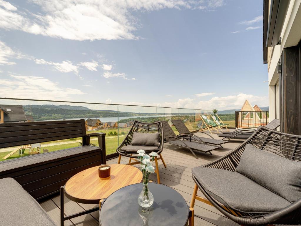 a balcony with chairs and a table with a view at Miral Apartament nad Jeziorem Czorsztyńskim in Kluszkowce