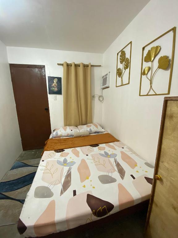 a small bedroom with a bed with a comforter at WIldFlower in General Luna