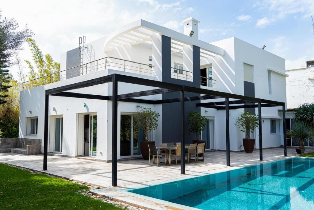 una villa con piscina y una casa en Bouskoura park, en Bouskoura