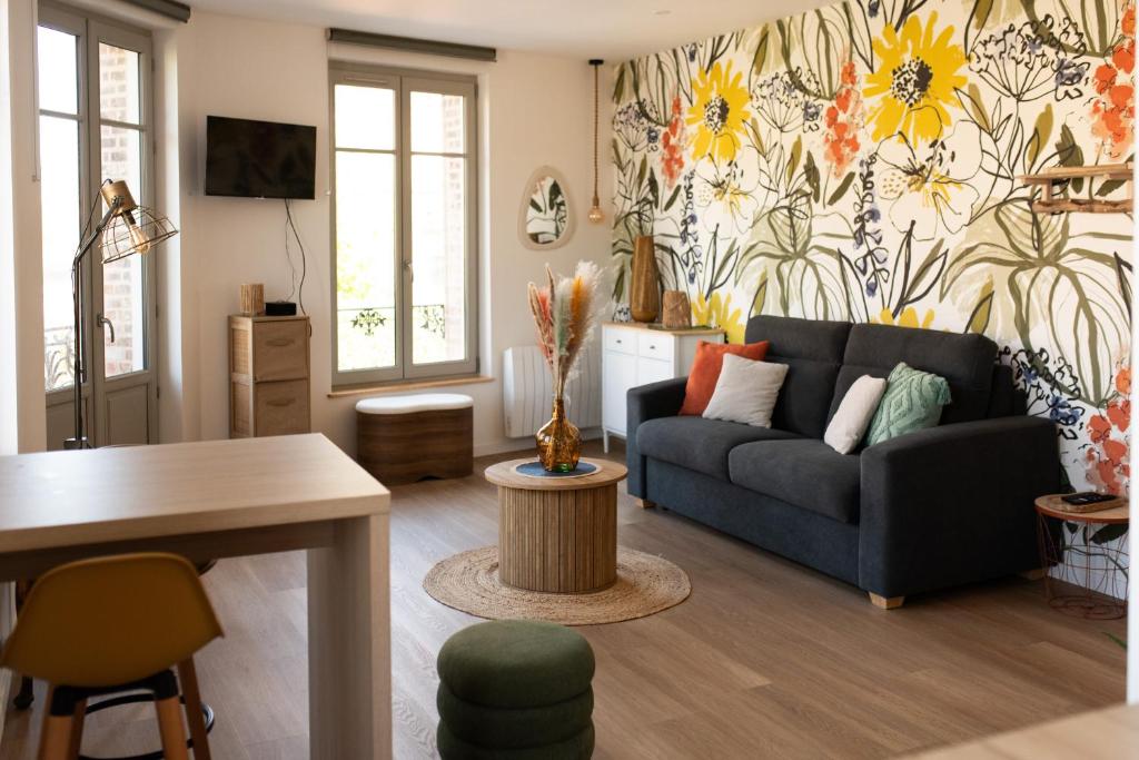 ein Wohnzimmer mit einer blauen Couch und Blumentapete in der Unterkunft Studio Lucien - Villa Bon Accueil proche mer in Mers-les-Bains