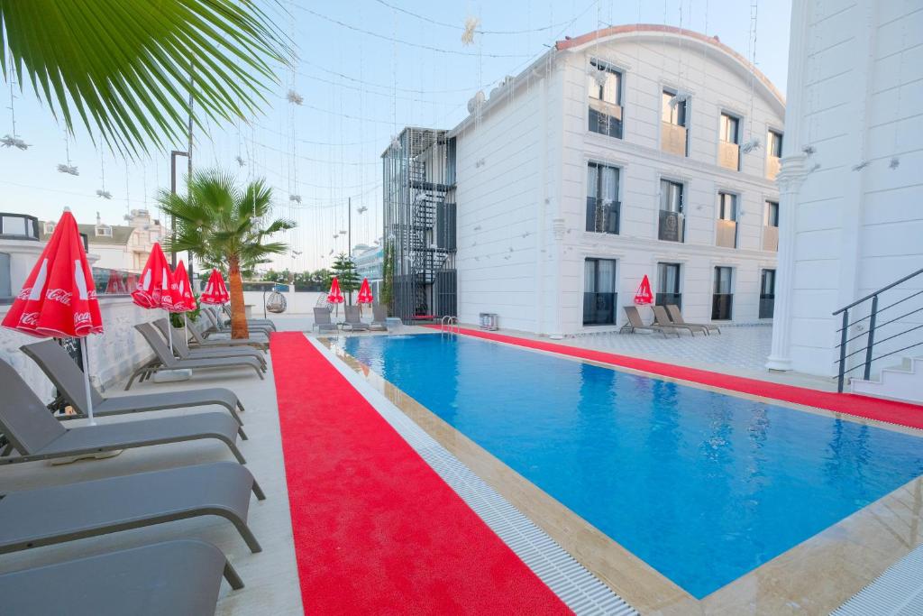 a swimming pool with a red carpet next to a building at Black Royal Belek in Belek