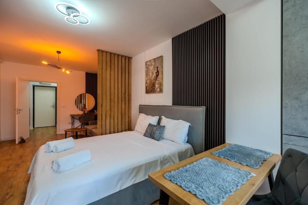 a bedroom with a large white bed and a table at Blvd Ivory Pipera nr 38 in Bucharest