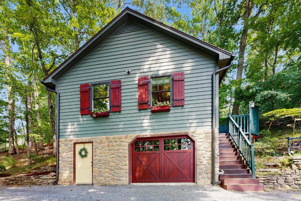 a gray house with red doors and a red garage at The Cottage at Sunset in Moneta